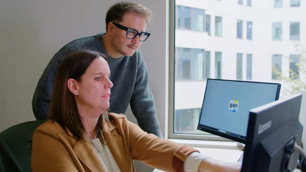 Deux collaborateurs travaillant ensemble sur un ordinateur au bureau